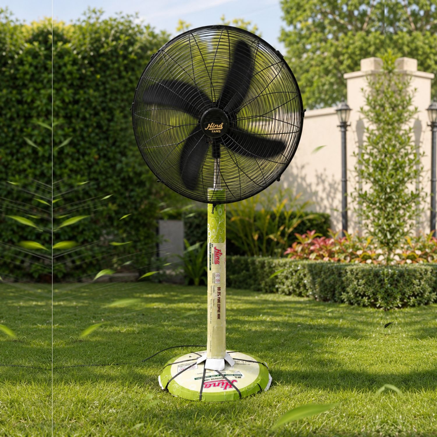 Hino black heavy duty pedestal fan with five blades standing in a garden